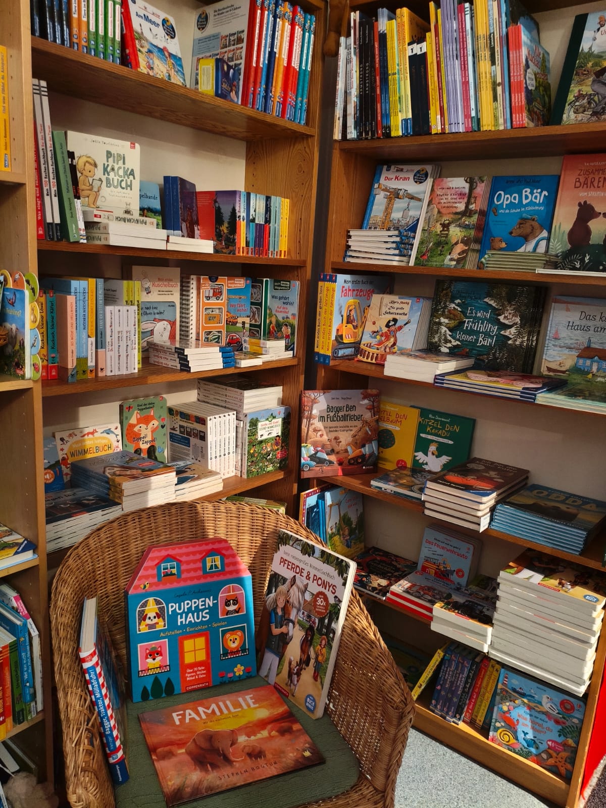 Gemütliche Kinderbuch-Ecke in der Mobilé Buchhandlung mit Korbsessel und ausgewählten Titeln