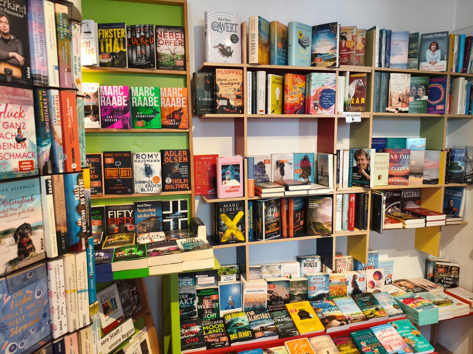 Bücherregal mit Belletristik und Krimis in der Mobilé Buchhandlung — Marc Raabe, Adler Olsen und viele Bestseller